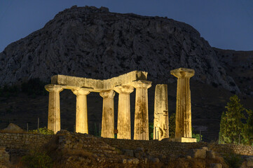 Temple of Apollo in Ancient Corinth Illuminated at Night with Acrocorinth in the Background,...