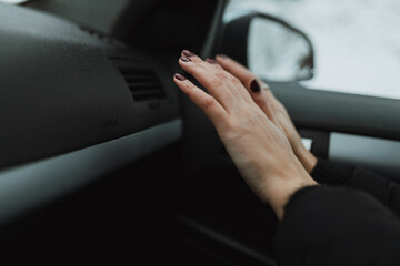 A woman checks the heating in the car