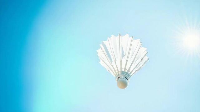 A white badminton shuttlecock is flying in the air. The shuttlecock is white and has a black stripe
