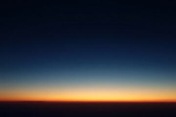 Obraz premium Dusk seen from airplane, horizon of orange and dark blue
