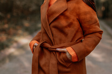 Woman wearing classy brown coat and orange knitting sweater, autumnal fashion cloth concept