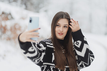 Beauty woman make selfie with smartphone outdoor at winter time