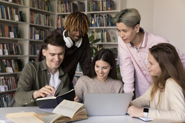 Creative teamwork in peer learning. Multiracial university students teens work together in classroom talk share knowledge brainstorm prepare for class project using notebook paper books written notes