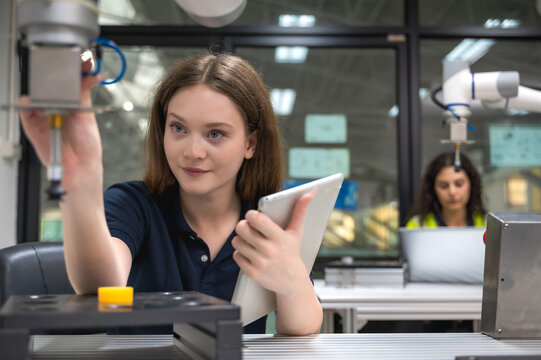 Caucasian robotic engineer working on automated artificial intelligent robot arm at machine learning center