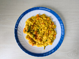Golden Rice and Vegetable Dish on a Blue-Rimmed Plate
