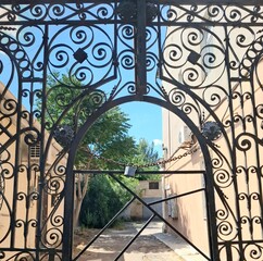wrought iron gate.
view of a beautiful metal gate closed with a large lock and chain