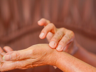 Close-up elderly woman hand taking her pulse on upper arm, senior pulse measurement. Healthy lifestyle people healthcare. Home care. Patient 