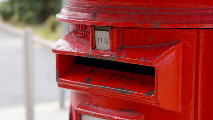 Close up of iconic red British mailbox used for traditional UK postal services