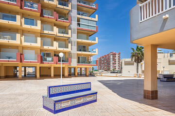 Spanish Style Bench and Modern Apartments in Sunlight