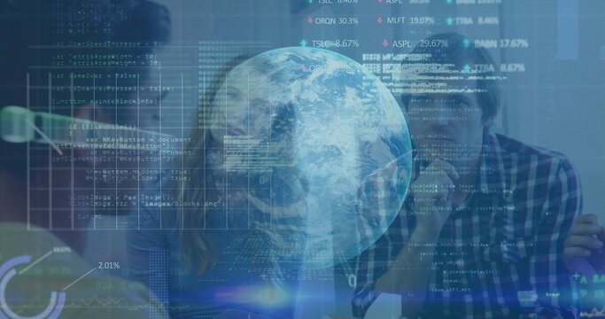 Collaborating developers typing code at office desk, with monitors, keyboard and holographic globe