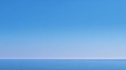 Calm ocean with gentle waves under a clear, cloudless blue sky stretching to the horizon.
