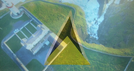Overlooking lighthouse complex on coastal cliff top with triangular graphic overlay, copy space