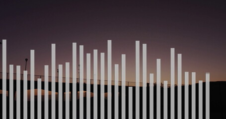 Stretching vertical white bars graphic overlay across walkway railing at dusk, with lampposts