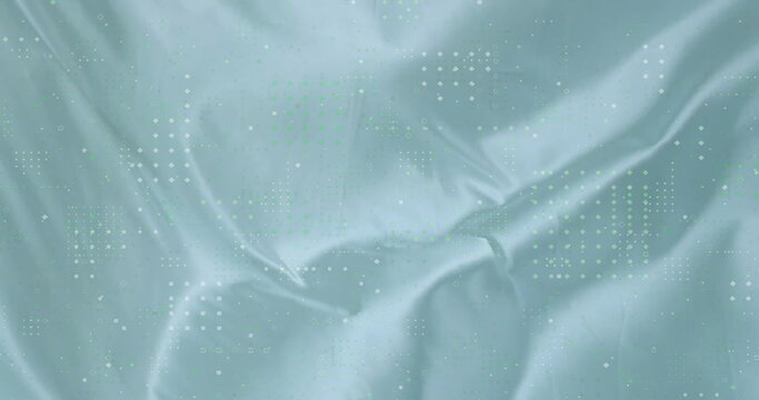 Fototapeta Displaying blue-green silky fabric shimmering under studio lights, featuring dotted square pattern