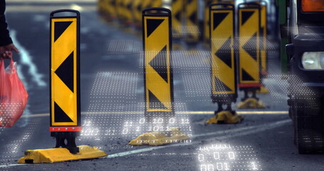 Guiding traffic bollard directing vehicles along street, with red shopping bags and vehicle front