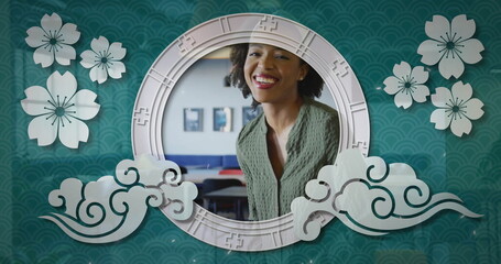 Posing mid adult Black woman wearing green cardigan in circular frame at studio, with floral motifs