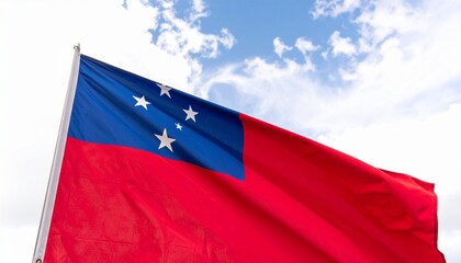 Samoa flag waving—red field with blue canton and five white stars forming the Southern Cross, fluttering against a cloudy sky.