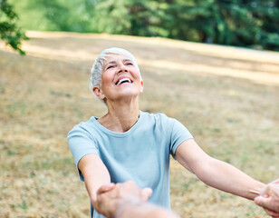 Happy active senior couple, portrait of an elderly woman with her husband dancing or swinging and holding hands and exercising  in park outdoors