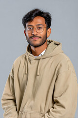 Obraz premium Half Body Portrait Of South Asian 20 Year Old University Male Student Wearing Casual Hoodie Against Plain Color Background