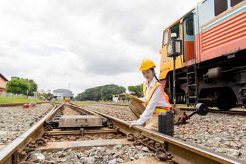 Asian young teen train engineer work check inspect service maintenance old locomotive railway track