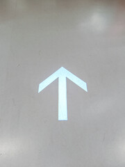 A glowing white arrow pointing upwards, a minimalist symbol for direction, guidance, and moving...