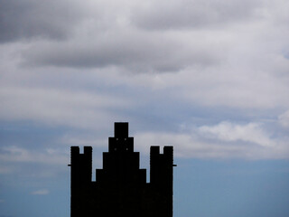Obraz premium black silhouette of a medieval castle tower in cloudy sky