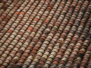 tradiational tiled roof with mixed reddish colored tiles in a european village