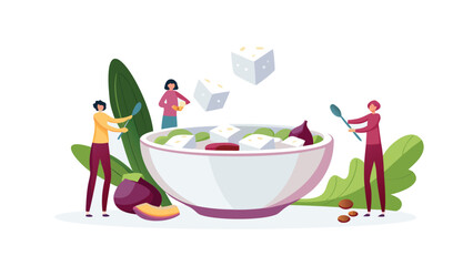 People preparing a salad with feta cheese and vegetables in a large bowl with spoons and leafy greens