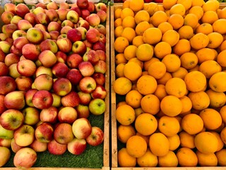 Abundant bounty:  Apples and oranges, a colorful harvest, overflowing from wooden crates.