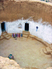 Matmata’s iconic troglodyte courtyard — circular architecture carved into rock reflects...