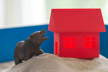 The concept of psychology. Sand
therapy. A bear figurine on
the background of a red house, in a blue
sandbox. Psychology. Therapy. PTSD