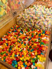 A vibrant explosion of color, from rainbow-hued marshmallows to a sea of colorful jelly beans.  Sweet treats galore.