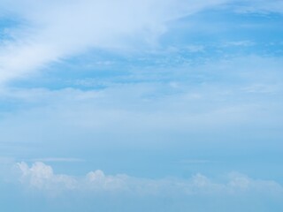 White, wispy clouds in a bright blue sky over a stunning sea
