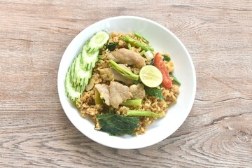 fried rice solf fermenting pork in black sweet soy sauce with slice cucumber couple lemon on plate 