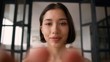 Webcam point of view POV Hispanic woman smile gen z user girl influencer female fingers typing on mobile phone texting message touch screen smartphone display online chatting gadget addicted at home