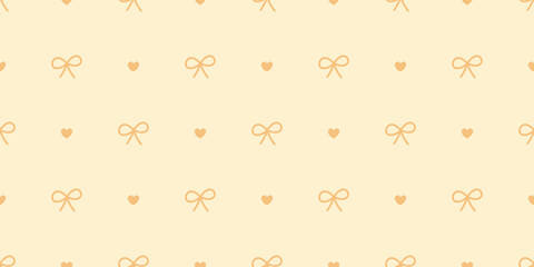 Seamless bow and heart pattern in warm yellow