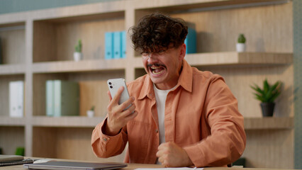 Angry man businessman Caucasian guy male business investor using mobile phone in office online bet...