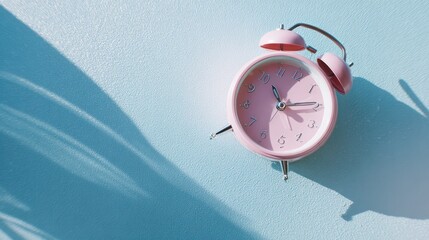 Vintage alarm clock on textured blue surface, minimalist pastel aesthetic with soft shadows.