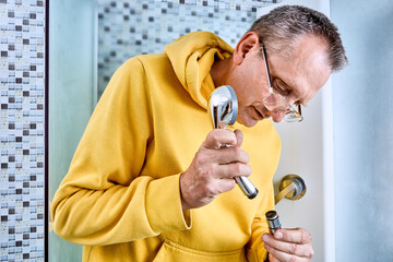 Shower sprayer installation involves plumber connecting showerhead to flexible shower hose, at end...