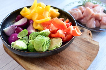 Close-up view of fresh colorful vegetables including bright bell pepper, red onion, and Brussels sprouts.