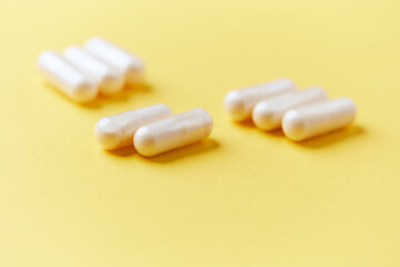 Collagen capsules. Bright paper background. Soft focus. Close up. Copy space.	