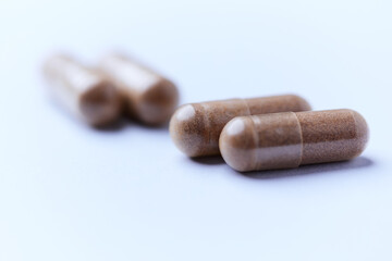 Ashwagandha (Withania somnifera) capsules. Concept for a healthy dietary supplementation. Bright paper background. Close up. Copy space.	