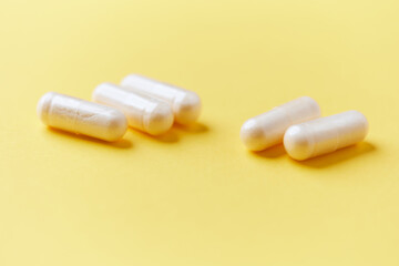 Collagen capsules. Bright paper background. Soft focus. Close up. Copy space.	