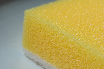 Close-up view of a yellow sponge showcasing intricate texture and pattern, highlighting its porous...