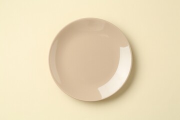 Stylish plate on beige background, top view