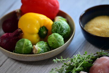 Close-up view of fresh colorful vegetables including bright bell pepper, red onion, and Brussels sprouts.