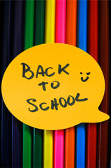 Texture of colored pencils vertically, and a label or emoji above it written back to school and a drawn a happy face near it.