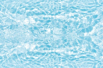 Blue water with ripples on the surface. Defocus blurred transparent blue colored clear calm water surface texture with splashes and bubbles. Water waves with shining pattern texture background.