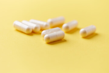 Collagen capsules. Bright paper background. Soft focus. Close up. Copy space.	