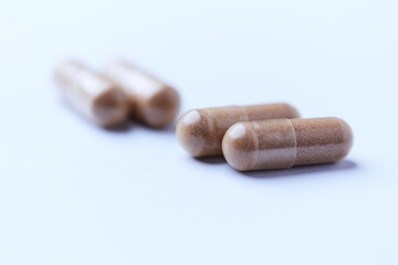 Ashwagandha (Withania somnifera) capsules. Concept for a healthy dietary supplementation. Bright paper background. Close up. Copy space.	